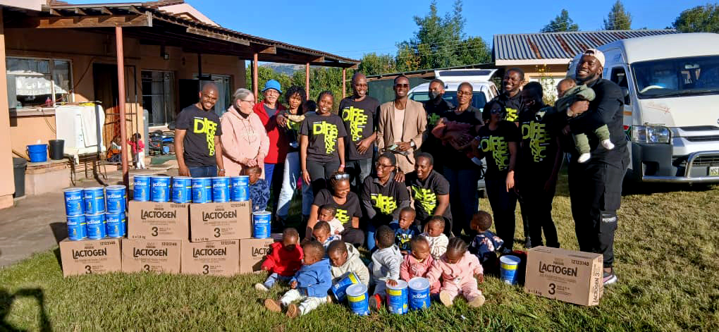 The Woolworths team with their amazing donations and our babies wearing their new tracksuits